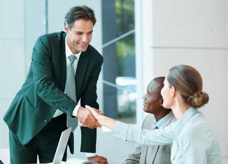 Investment professionals shaking hands in a modern office